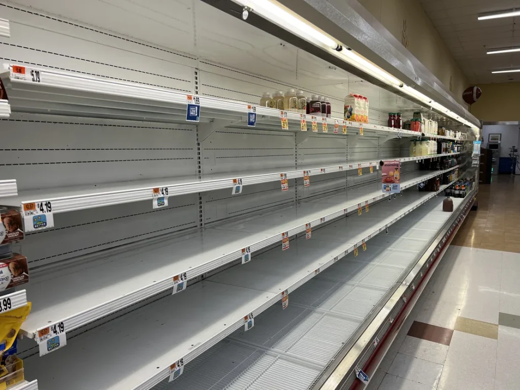 Empty grocery store shelves due to delayed shipments caused by severe weather disruptions