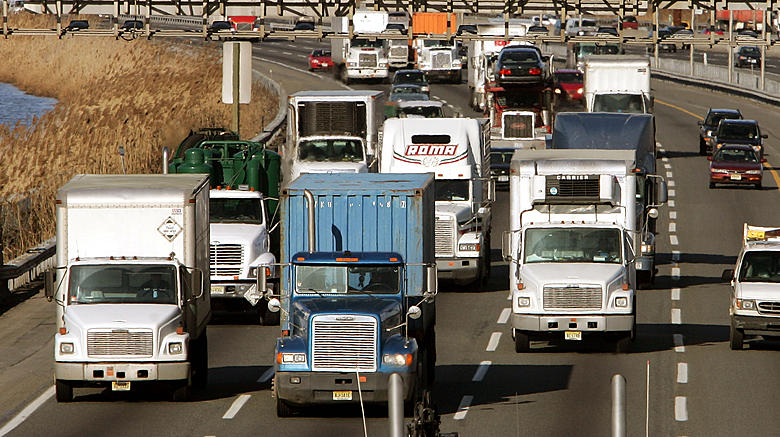 Multiple freight trucks in slow-moving highway traffic, highlighting congestion issues affecting trucking efficiency in 2025